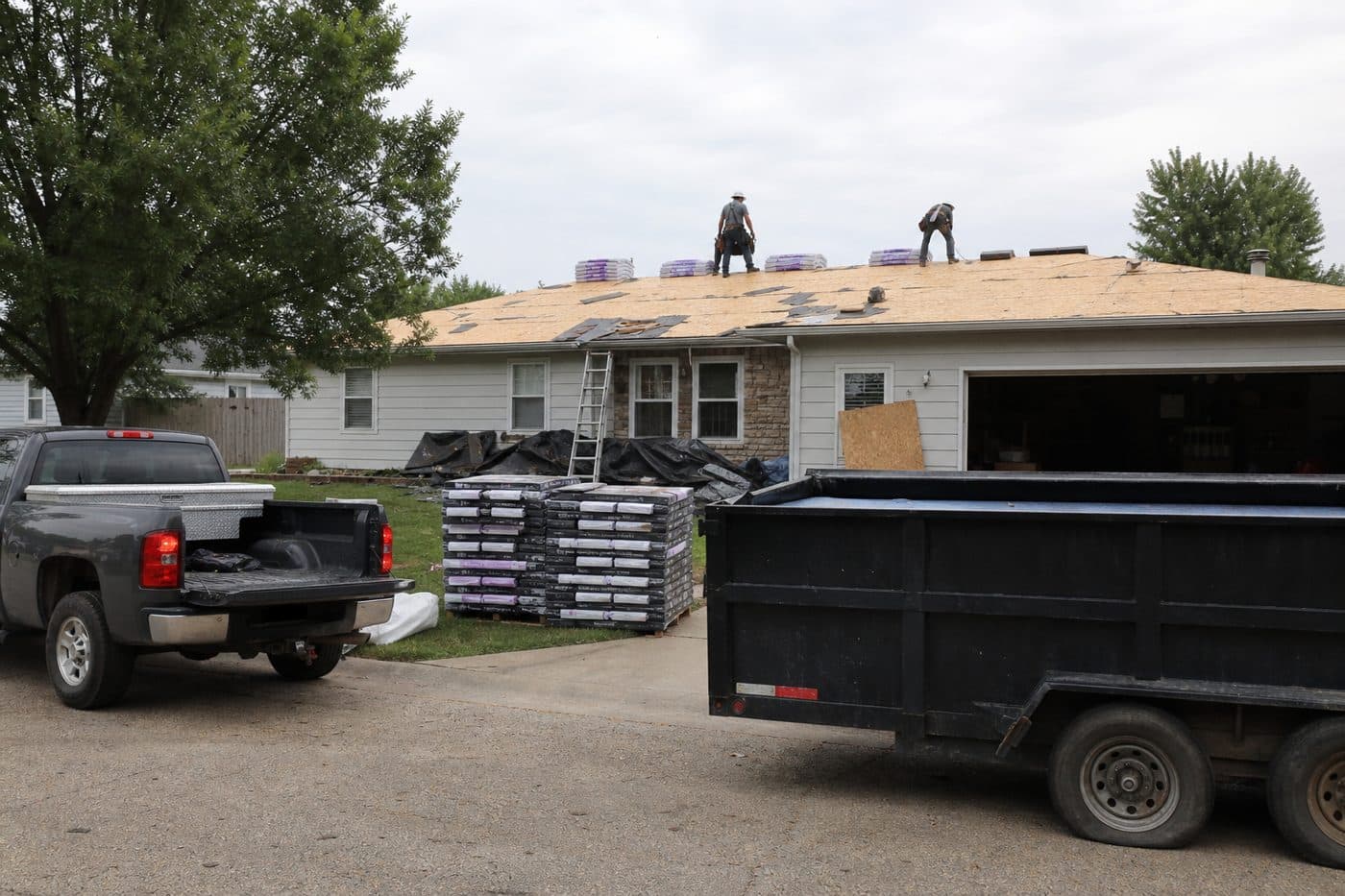 Roofers working on a residential roof before the next stage of installation